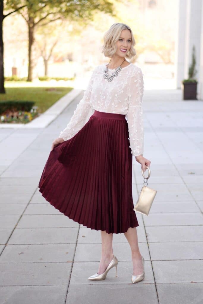 Amy Ann Arnold's holiday look featuring a burgundy midi skirt and sheer blouse.