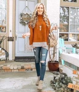 Cristina Gamarnik from OC Mom Lifestyle styles her gray booties with jeans and a sweater,