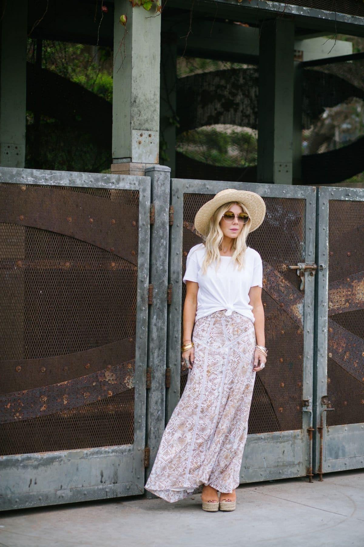 maxi skirt outfit with knotted white top, sandals, and straw hat