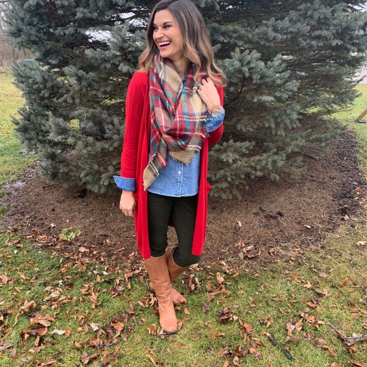 outfit with a scarf over a chambray shirt, red long cardigan, black jeans and tan boots