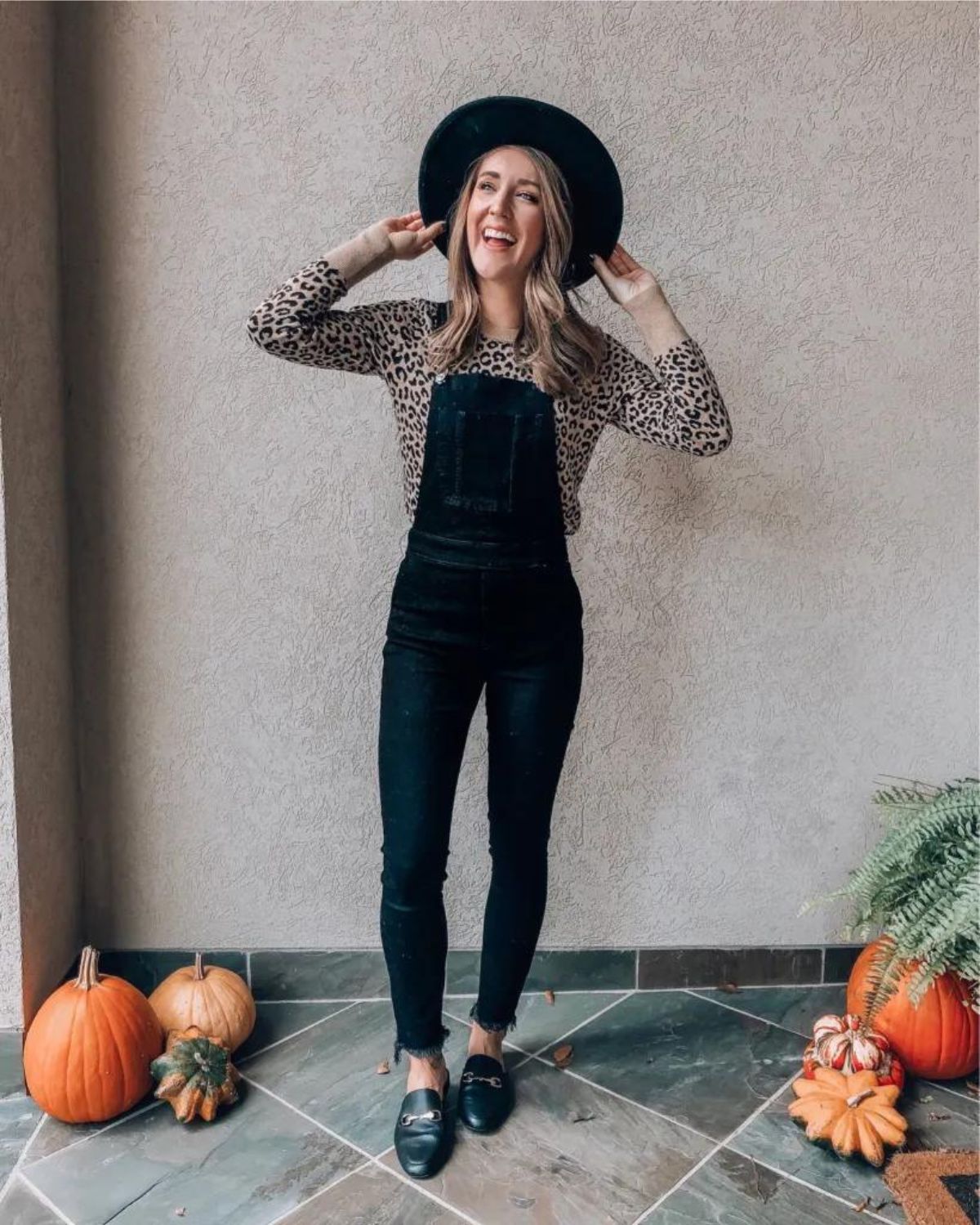 styling black overalls with long sleeve leopard print top