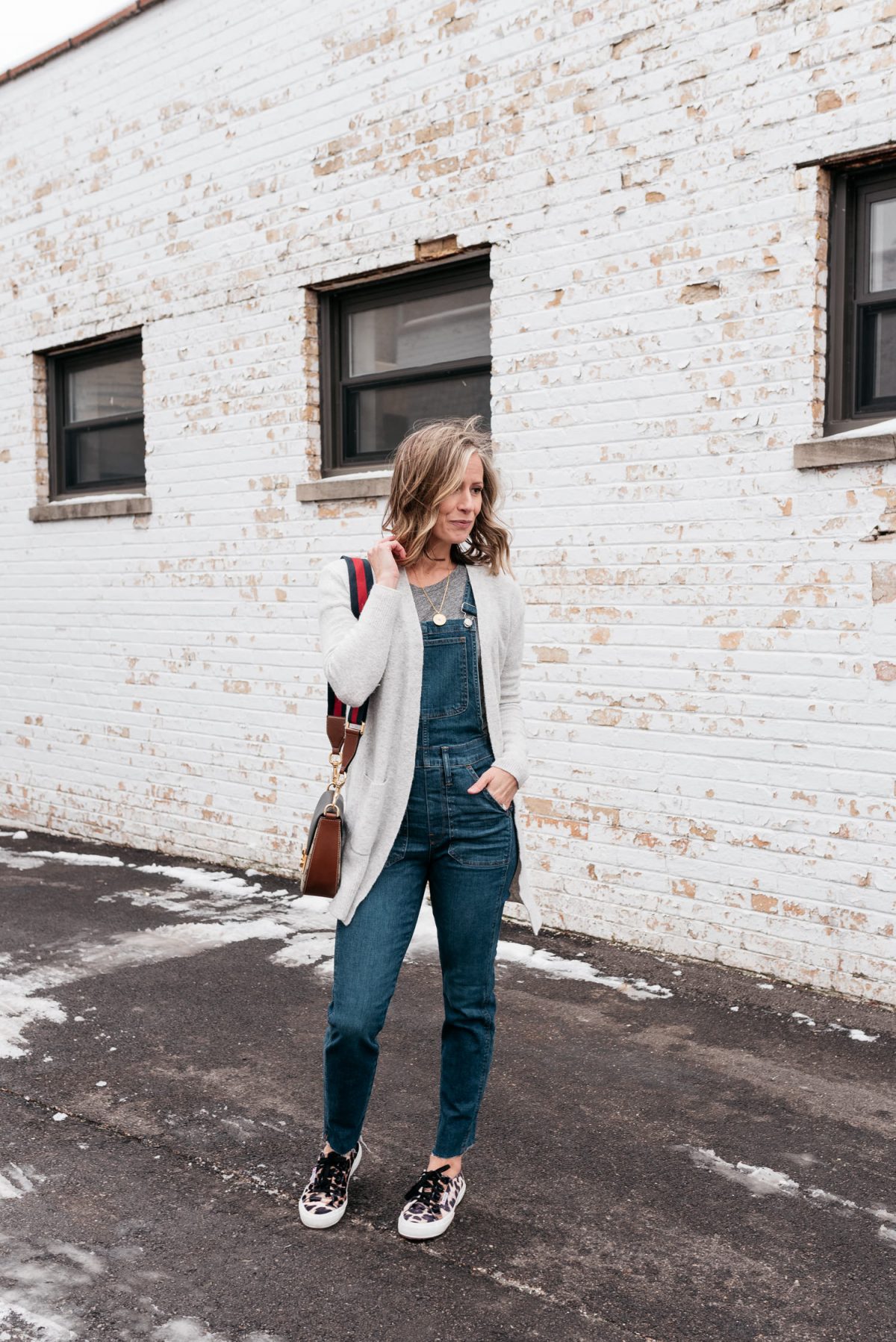 outfit that has cardigan, leopard sneakers, and overalls