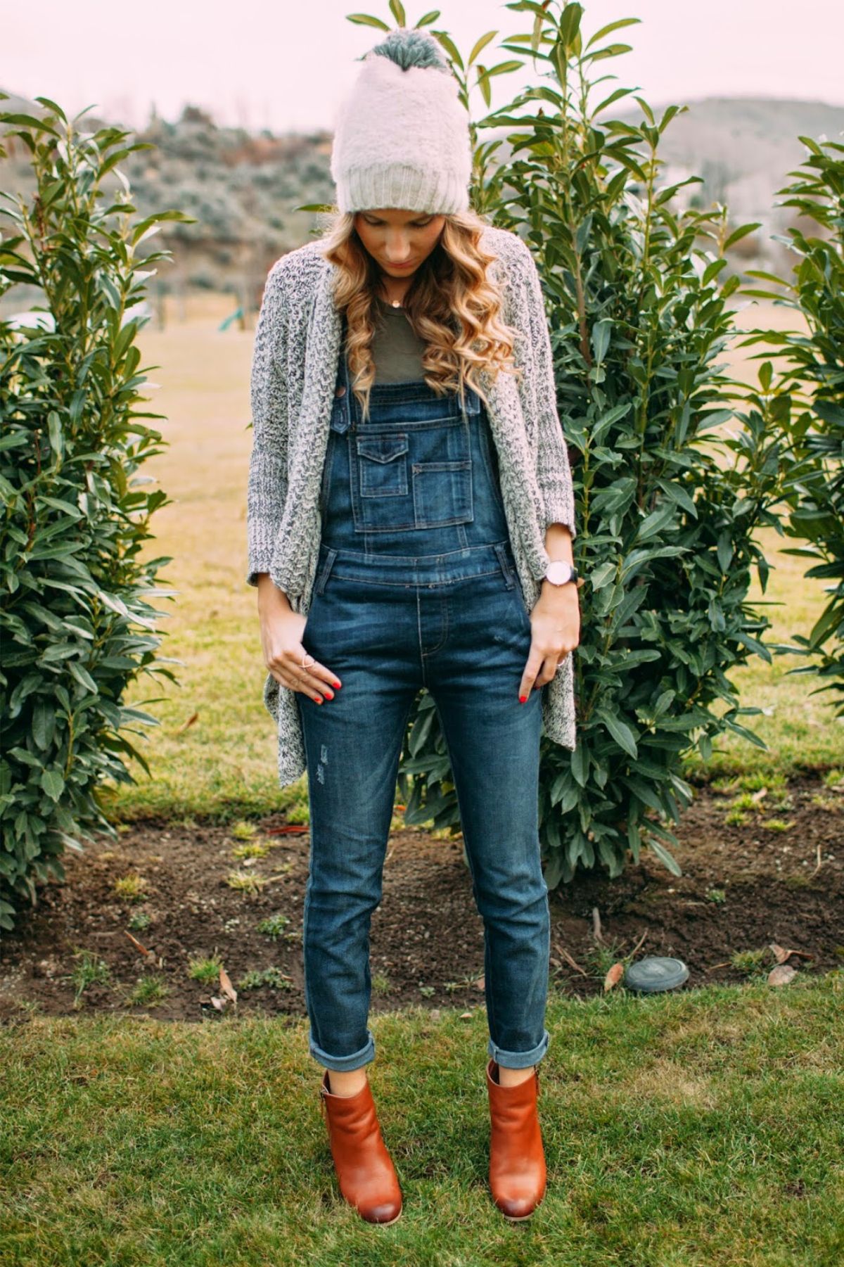 styling overalls with beanie and cardigan