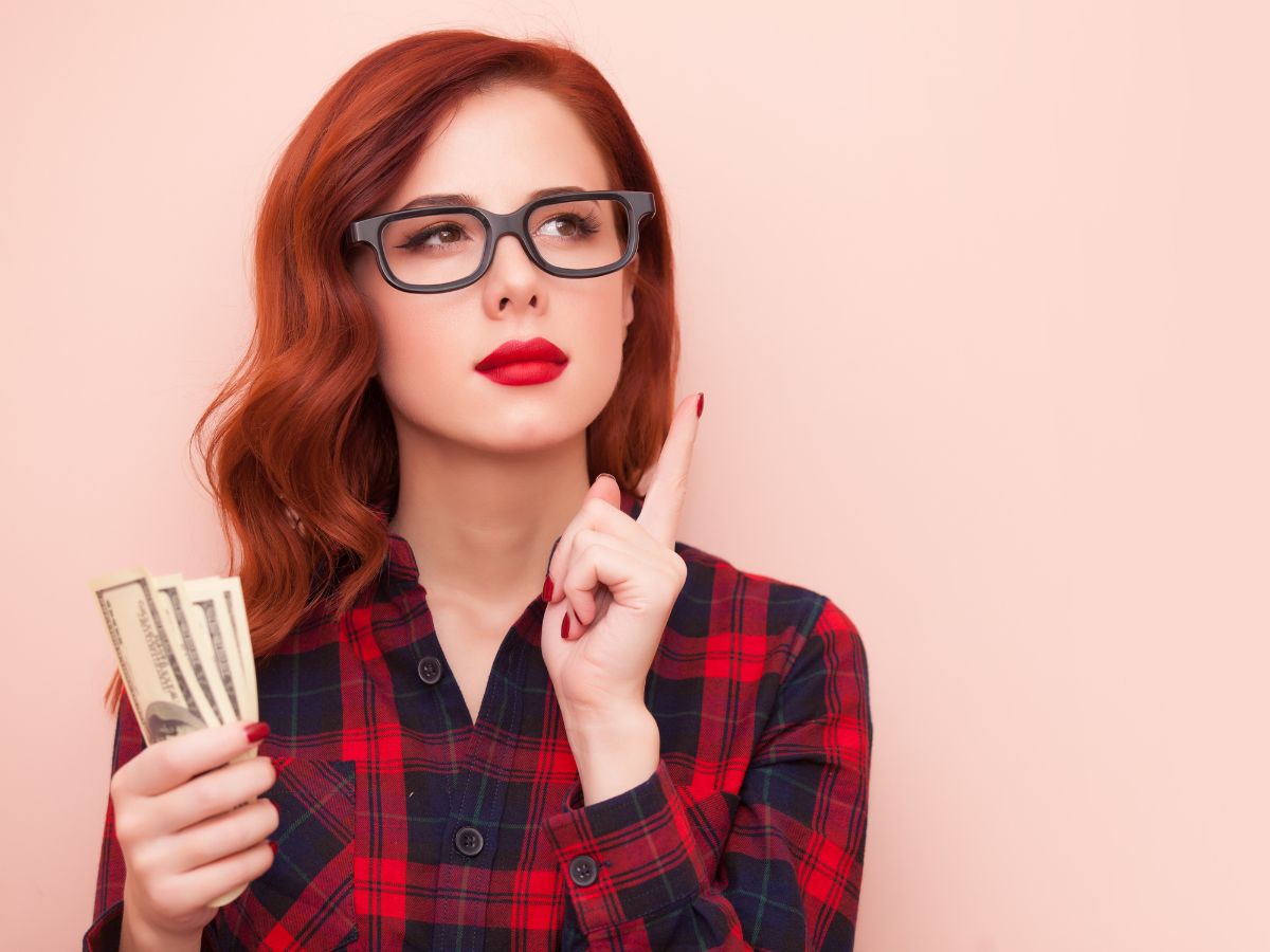 girl holding money and thinking to herself