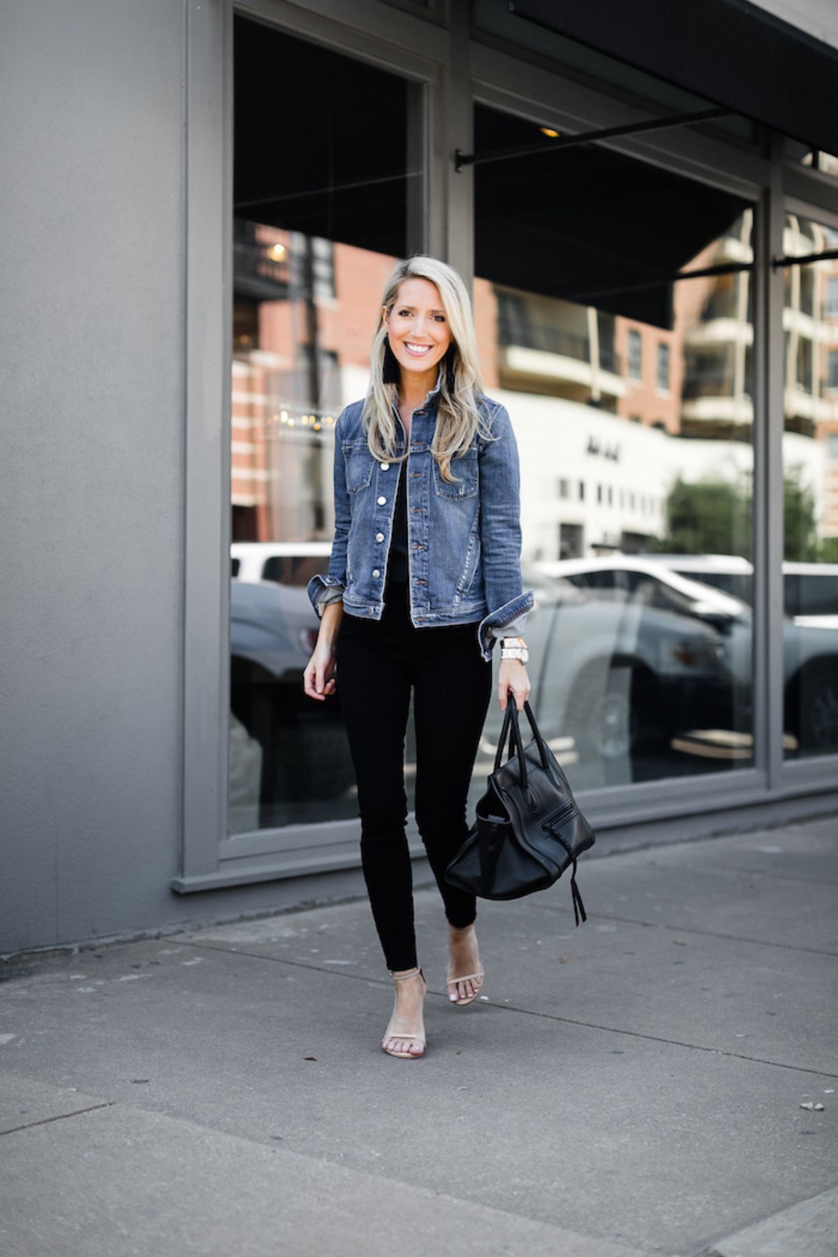 Krystal Davis in a jean jacket, black top, black jeans, and heels.