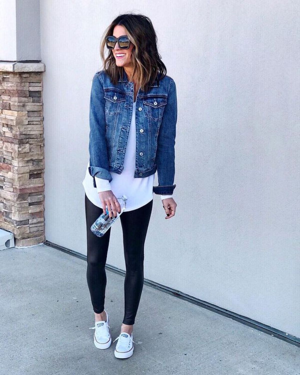 Jen Reed styled her dark jean jacket with a white shirt, white converses, and black pants.