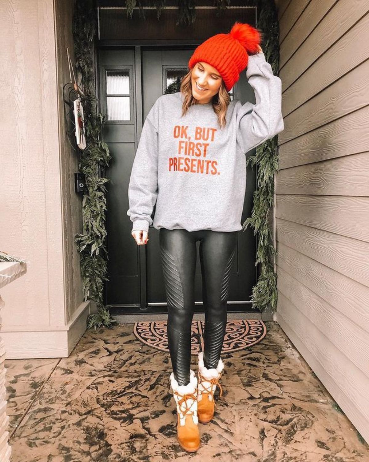 outfit with red beanie, graphic sweatshirt, leggings, and boots