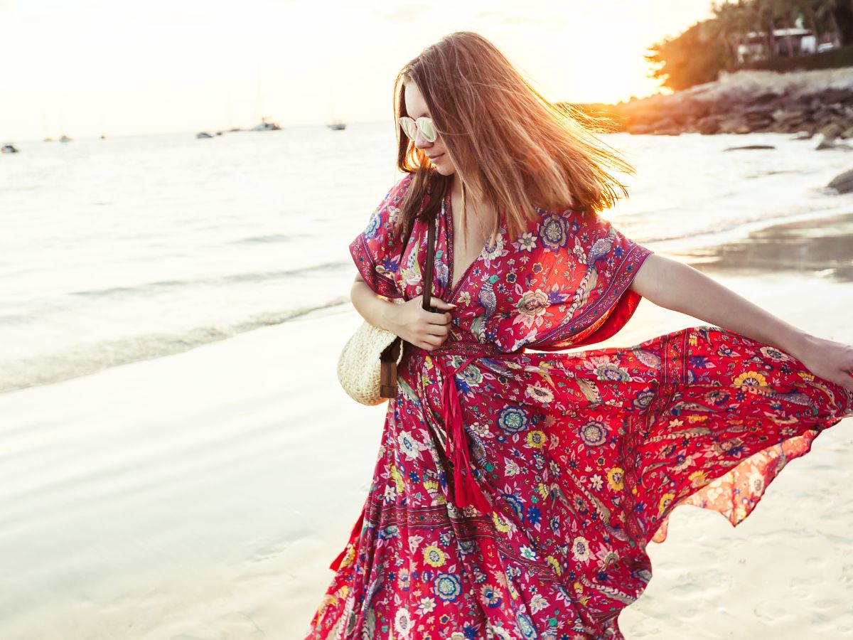 woman wearing red floral maxi dress on the beach