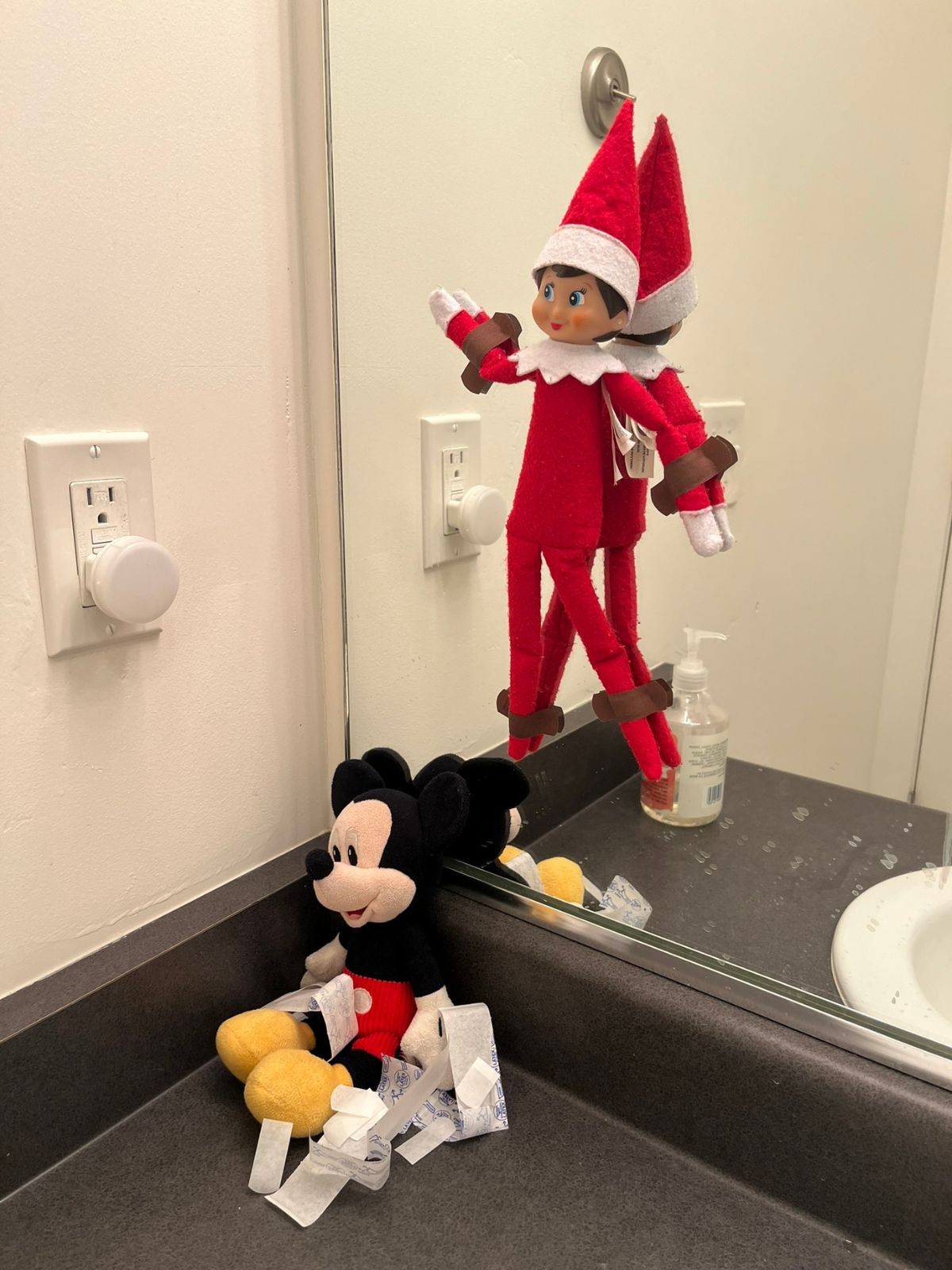 elf tied to a mirror with bandaids