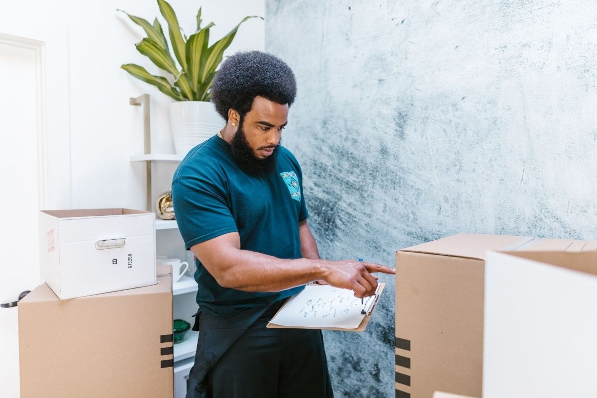 man in blue crew neck t-shirt holding clipboard